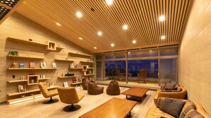 A modern interior with wooden shelves, seating, and a large window.