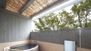 A stone hot tub with a wooden bench, a small window, and a wooden ceiling structure. - Kannawa Onsen Zekkei No Yado Sakuratei (Beppu)