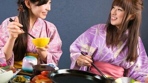 Two individuals in traditional attire, a table with various dishes, and a black pot. - Hosenji Onsen Ryusenkaku (Kokonoe)
