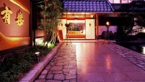A building entrance with a stone pathway leading to a glass door. - Yuraku (Misasa)
