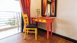 A room with a desk, chair, and a window with curtains. - Reddoorz Plus @ The Ridge Tagaytay City (Tagaytay)