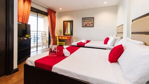 Habitación de hotel con dos camas, televisor, escritorio y ventana con cortinas.