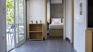 A modern hotel room with a bed, a small wooden shelf, a nightstand, and a large window. - 12 Keys Athens Apartments (Athens)