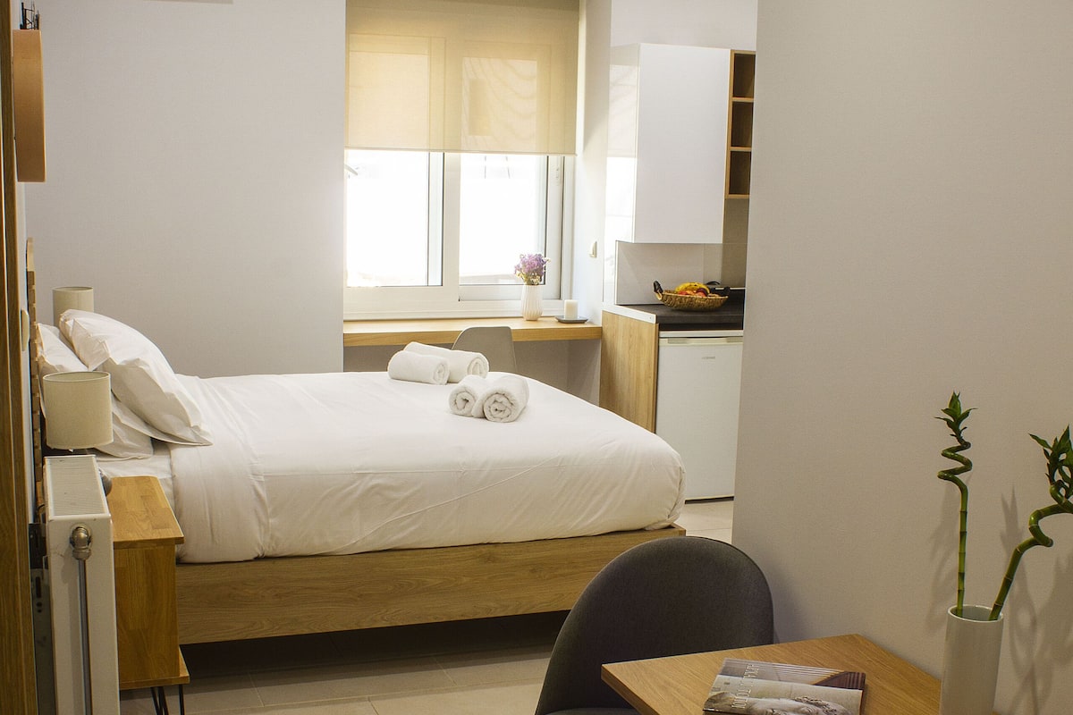 Une chambre à coucher comprenant un lit, une table de chevet et un bureau avec une chaise.