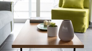 A modern living room with a wooden coffee table, a green armchair, and a white sofa. - 12 Keys Athens Apartments (Athens)