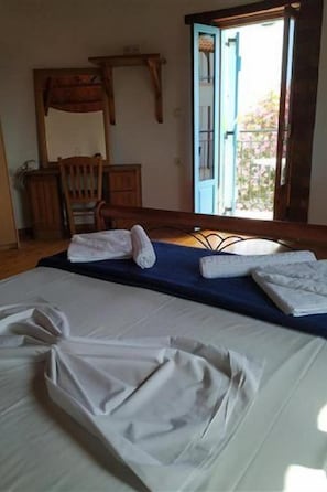 A bedroom with a bed, a chair, a desk, and a window with a view. - Pardalakis Studios (Platanias)