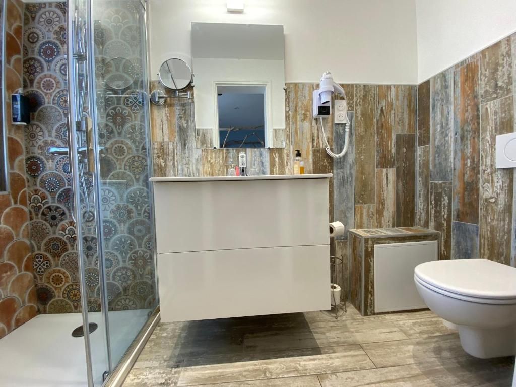 Un baño con ducha, inodoro y tocador.