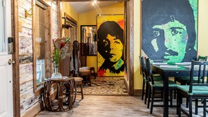 A dining area with a large mural, wooden furniture, and a patterned floor.