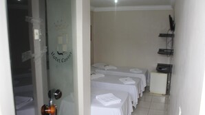 A hotel room with a bed, a desk, and a small refrigerator. - Hotel Castelo (Palmas)