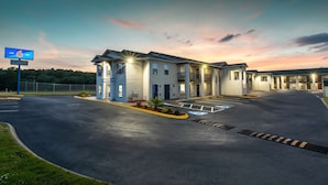 A motel with a large parking lot, a sign indicating room number 6, and a well-lit entrance. - Motel 6 Greenville, SC - I-85 Near Downtown (Greenville)