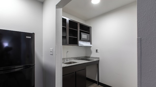 A compact kitchen with a black refrigerator, a microwave, and a double sink. - Motel 6 Greenville, SC - I-85 Near Downtown (Greenville)