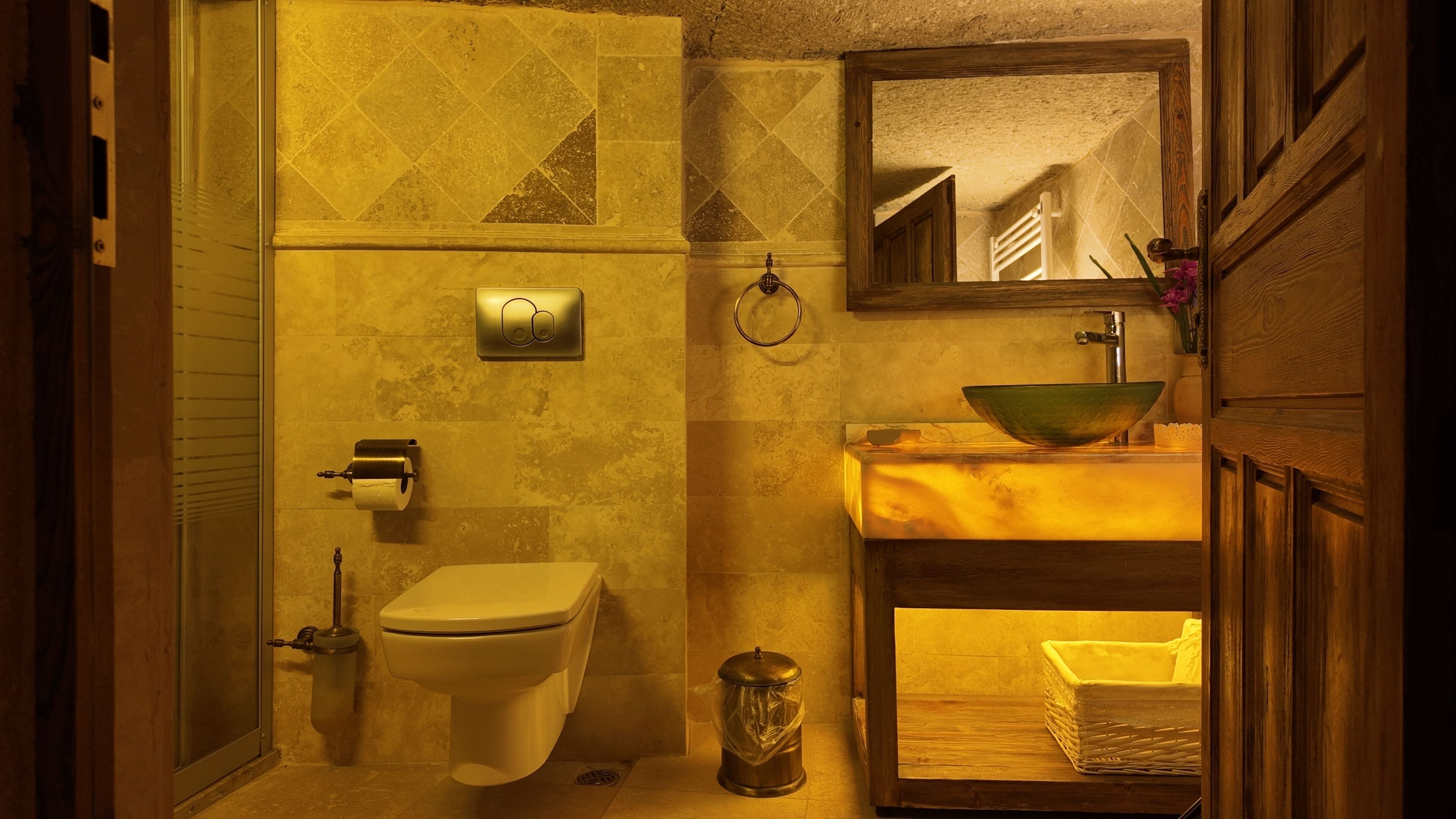 A bathroom with a toilet, sink, and mirror.