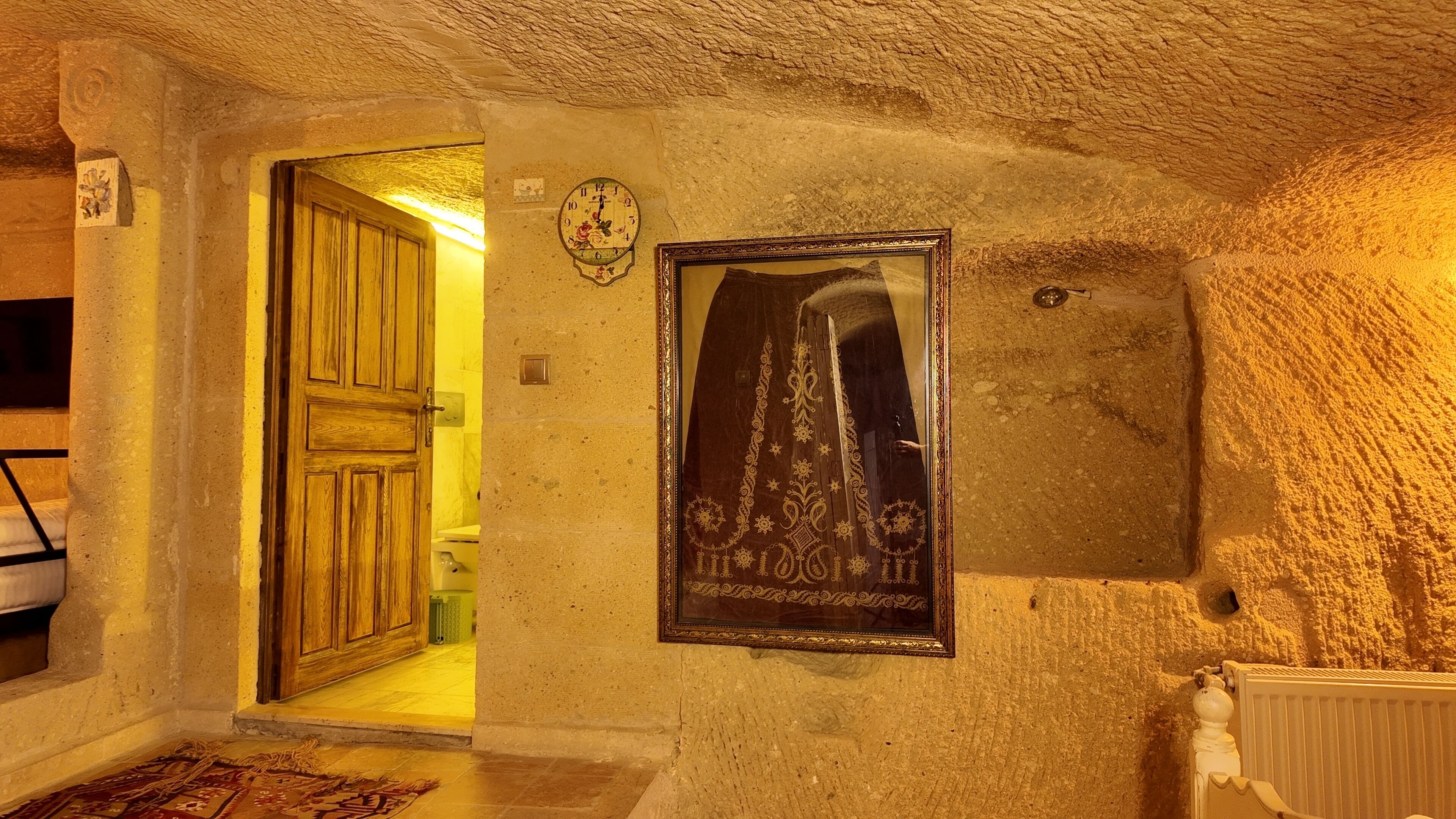 A rustic interior with a wooden door, a framed picture, and a textured wall.