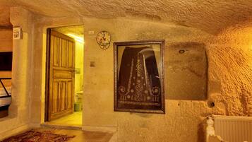A rustic interior with a wooden door, a framed picture, and a textured wall.