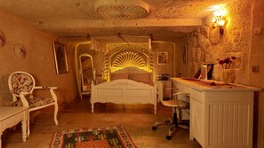 A bedroom with a bed, a desk, a chair, and a mirror. - Iris Cave Cappadocia (Ürgüp)