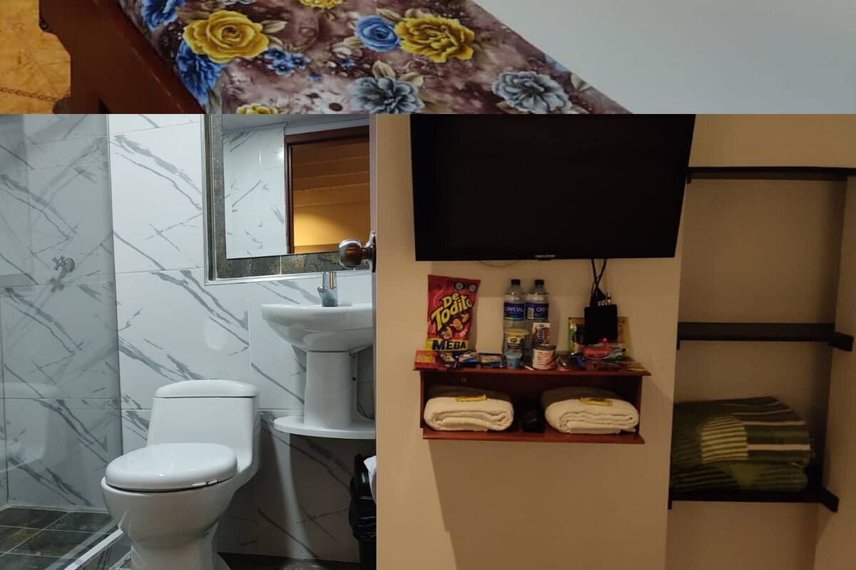 Ein Hotelzimmer mit zwei Betten, einem Badezimmer mit Toilette und Waschbecken sowie einem Regal mit Pflegeartikeln.