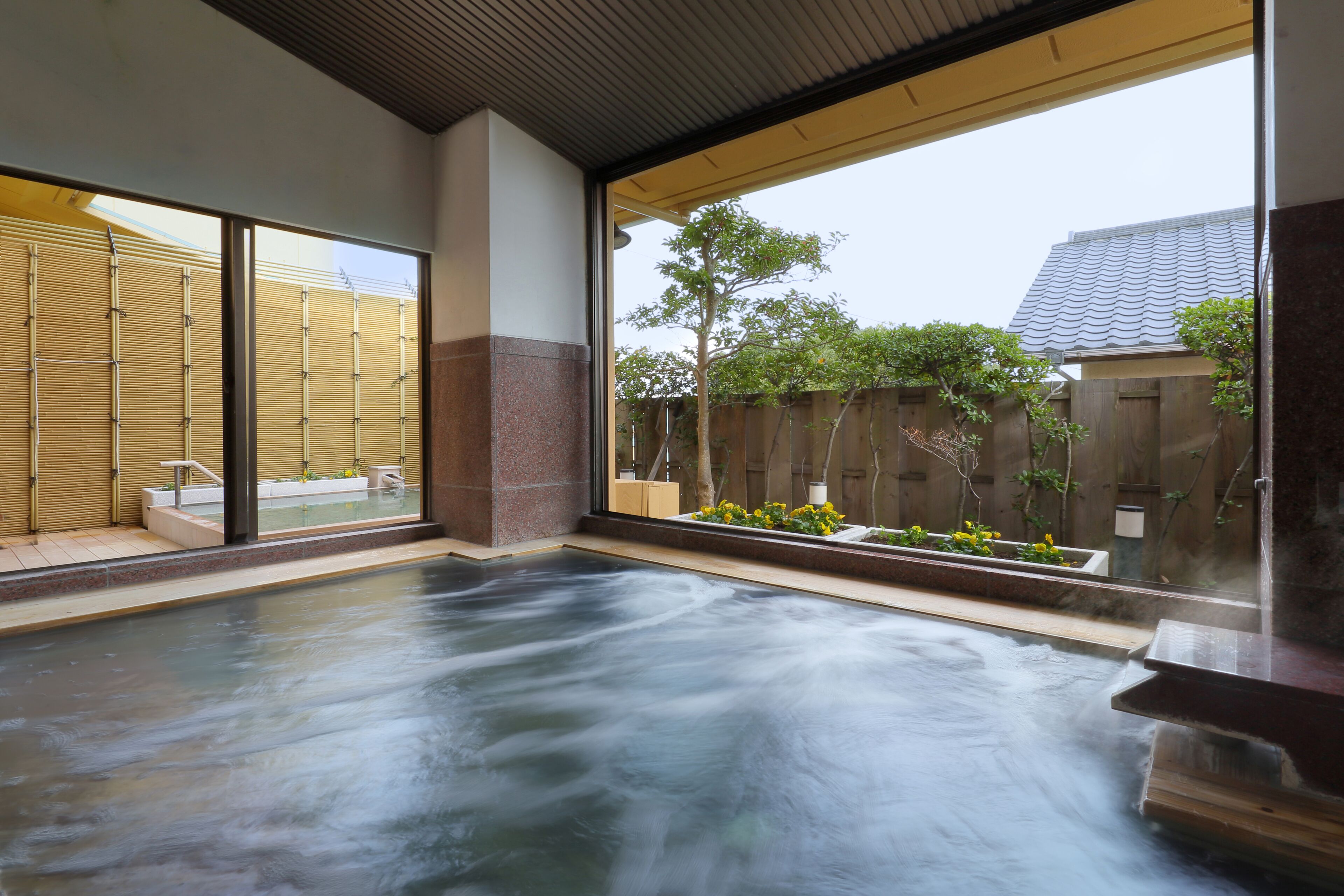 A hot tub area with a view of a wooden fence and trees.