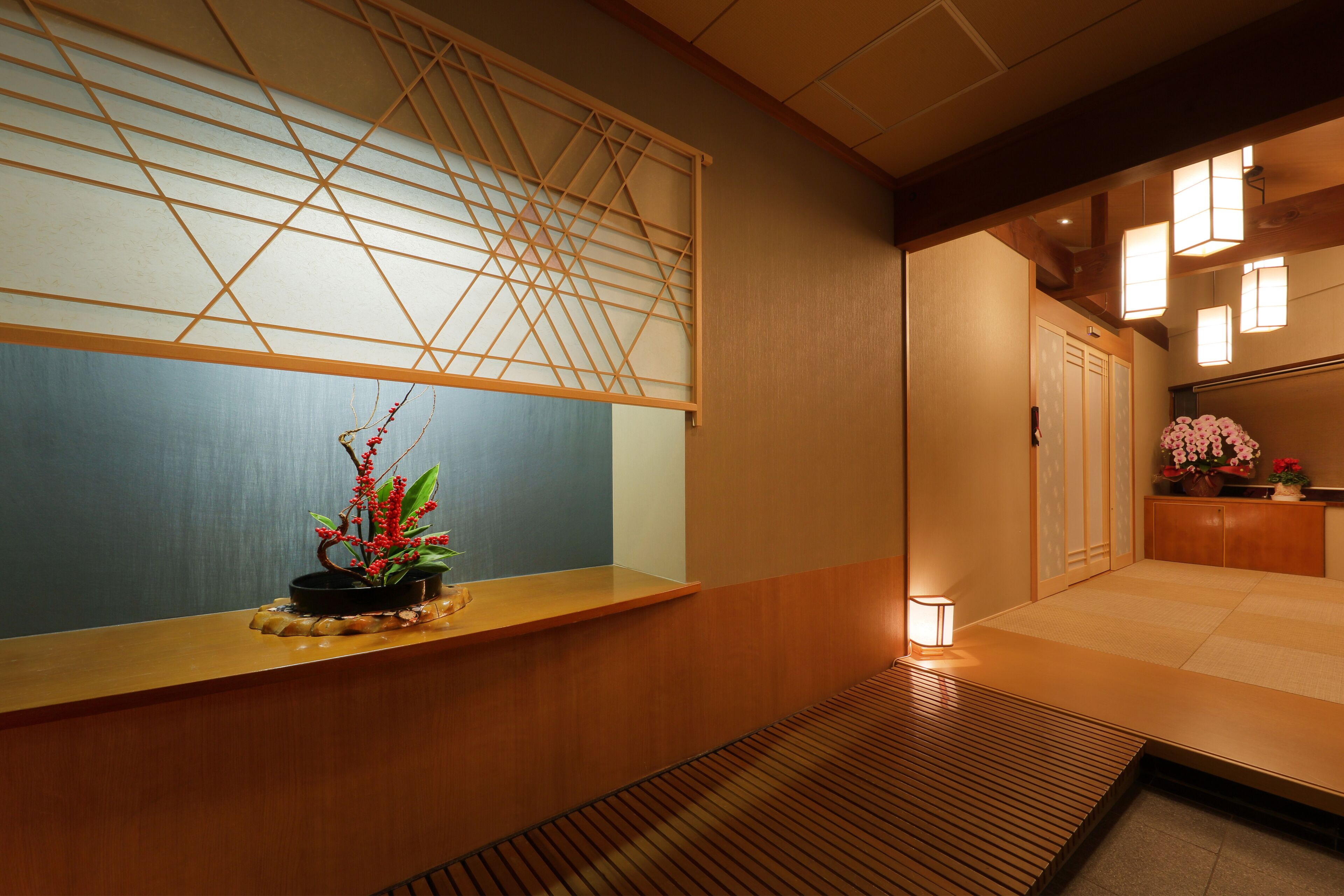 Um interior japonês tradicional com tatames, um painel shoji e um pequeno jardim interno.