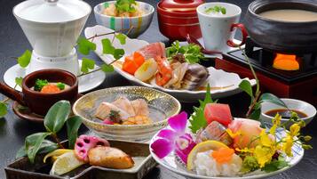 A variety of dishes and bowls on a table, including seafood, vegetables, and a hot pot.