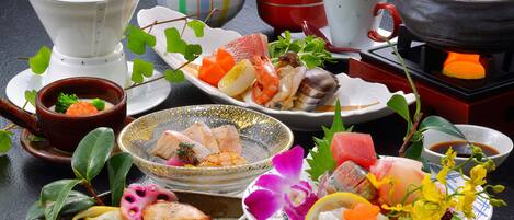 A variety of dishes and bowls on a table, including seafood, vegetables, and a hot pot.