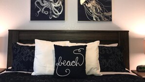 A bed with a dark headboard, two pillows, and a wall with two framed artworks depicting marine life. - Luxury Villa  2 miles from Disney  (Kissimmee)