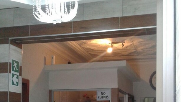 A reception area with a counter, a sign indicating no refunds, and a no credit please sign.