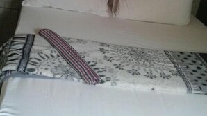 A bed with two pillows and a patterned blanket.