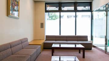 A modern waiting area with a sofa, a coffee table, and a large window providing a view outside.