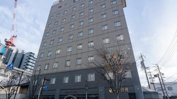 A multi-story hotel building with a modern architectural design, featuring a prominent entrance and a visible signboard.