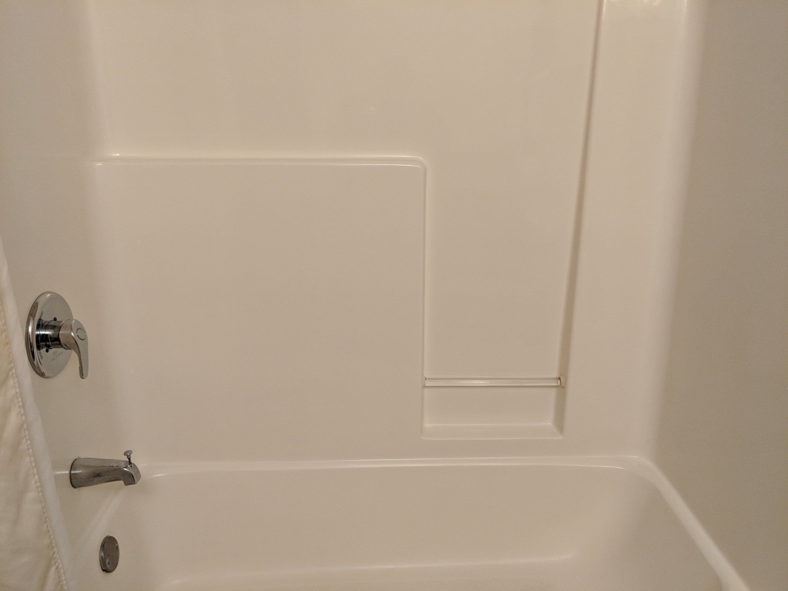 A white bathtub with a chrome faucet and a single lever handle.