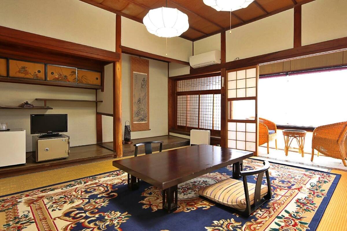 Ein traditioneller japanischer Raum mit Tatami-Böden, einem niedrigen Tisch und Schiebetüren.