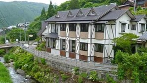 Ein mehrgeschossiges Gebäude im traditionellen Baustil, neben einem Fluss gelegen.