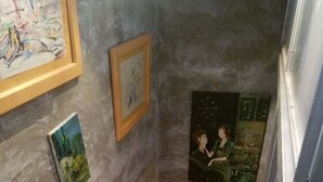 Eine enge Treppe mit Holzstufen, die abwärts führt.