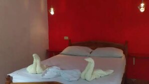 Una cama con sábanas blancas y dos toallas con forma de cisne.