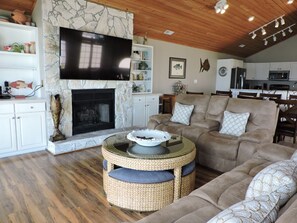Cozy living room with a fireplace, flat-screen TV, and comfortable seating area.