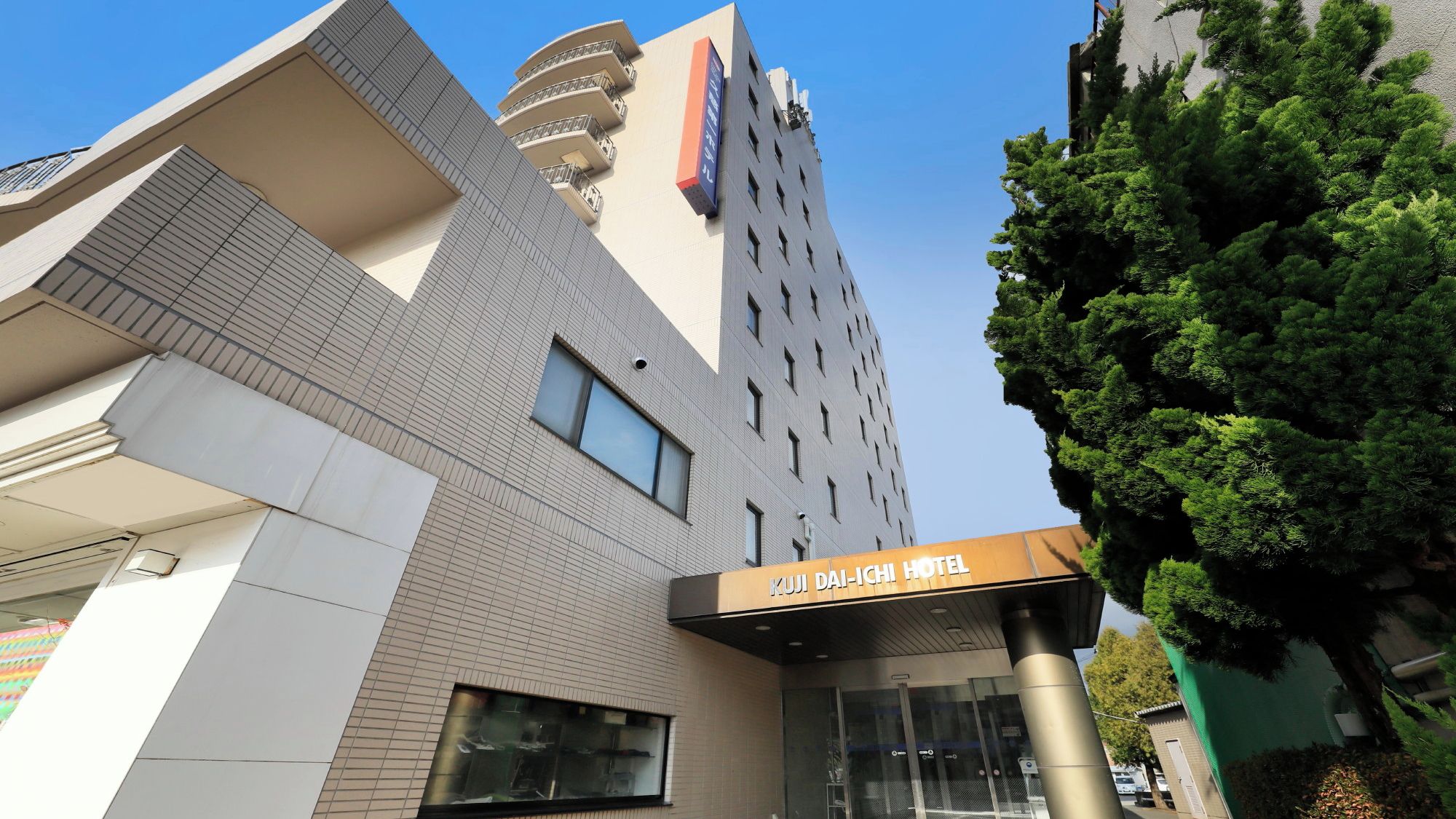 A modern hotel building with a prominent sign for 'KURALI-ISHI HOTEL' and a visible entrance.