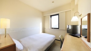 Habitación de hotel con cama, mesita de noche, lámpara, televisor y ventana.
