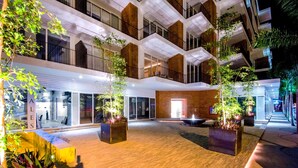 Een meerlaags atrium met een centrale open ruimte, omringd door balkons en een glazen gevel.