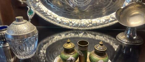 A display of antique silverware and glassware with intricate designs.