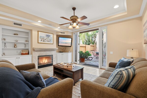 A living room with a fireplace, comfortable seating, and a television. - La Jolla Mar | 3BR Villa w/ Ocean Views in Village (San Diego)