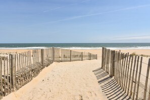 A sandy beach with a wooden fence leading to the ocean. - Direct Beach Access-1st Floor Oceanfront Paradise! Newly Renovated Beach Getaway (Ocean City)