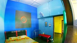 A room with a bed, a desk, a chair, a mirror, and a door. - Olivia Homestay (Banyuwangi)