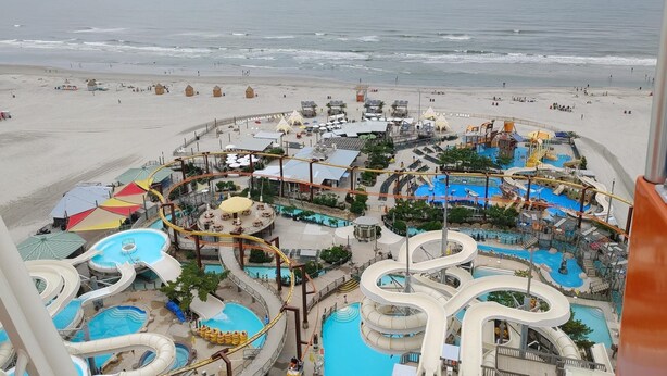 Un parc aquatique doté de nombreux toboggans et de plusieurs piscines, offrant une vue sur la plage.