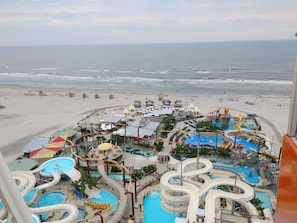 Ein Wasserpark mit mehreren Rutschen und Pools mit Blick auf einen Strand.
