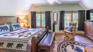 Une chambre à coucher avec un lit, une chaise, une commode et une fenêtre avec des rideaux.