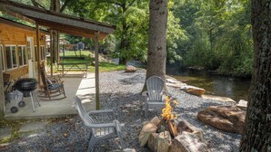 A covered outdoor area with a fire pit, chairs, and a grill. - Deep Creek Cottage-Creek side- close to the Polar Express (Bryson City)