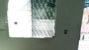 Ein Zimmer mit großem Fenster, einer Tür und Fliesenboden.