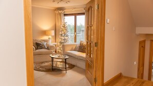 Un salon chaleureux avec un canapé, une table basse et un sapin de Noël.