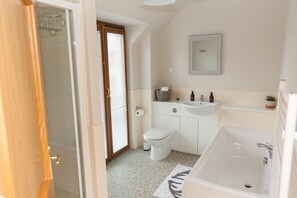 Une salle de bain moderne équipée d’une douche, de toilettes, d’un lavabo et d’une baignoire.