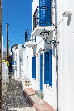 Eine enge Straße mit weißen Gebäuden und blauen Türen.